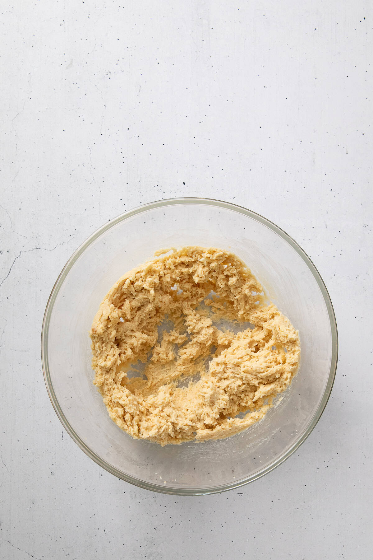 Creamed butter and sugar mixture in a glass mixing bowl.