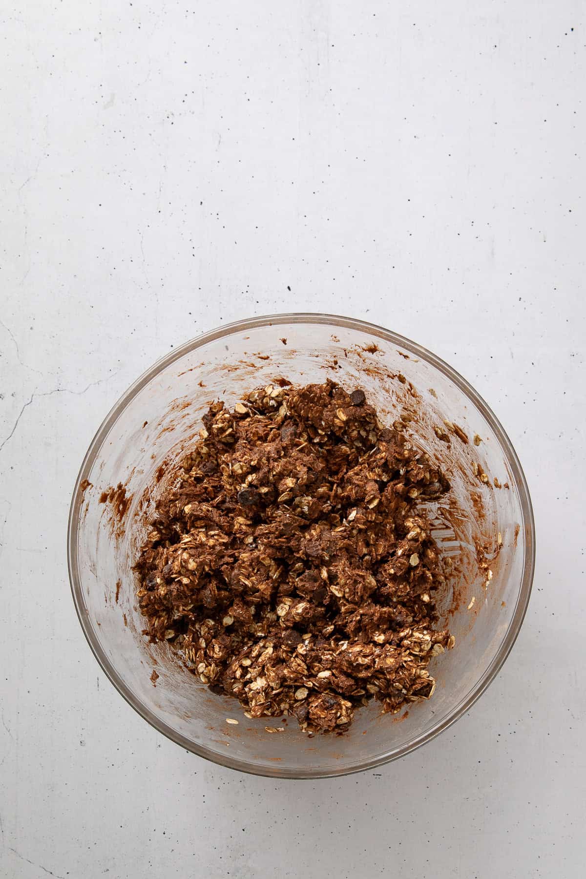 Chocolate oatmeal cookie dough with oats and chocolate chips mixed in.