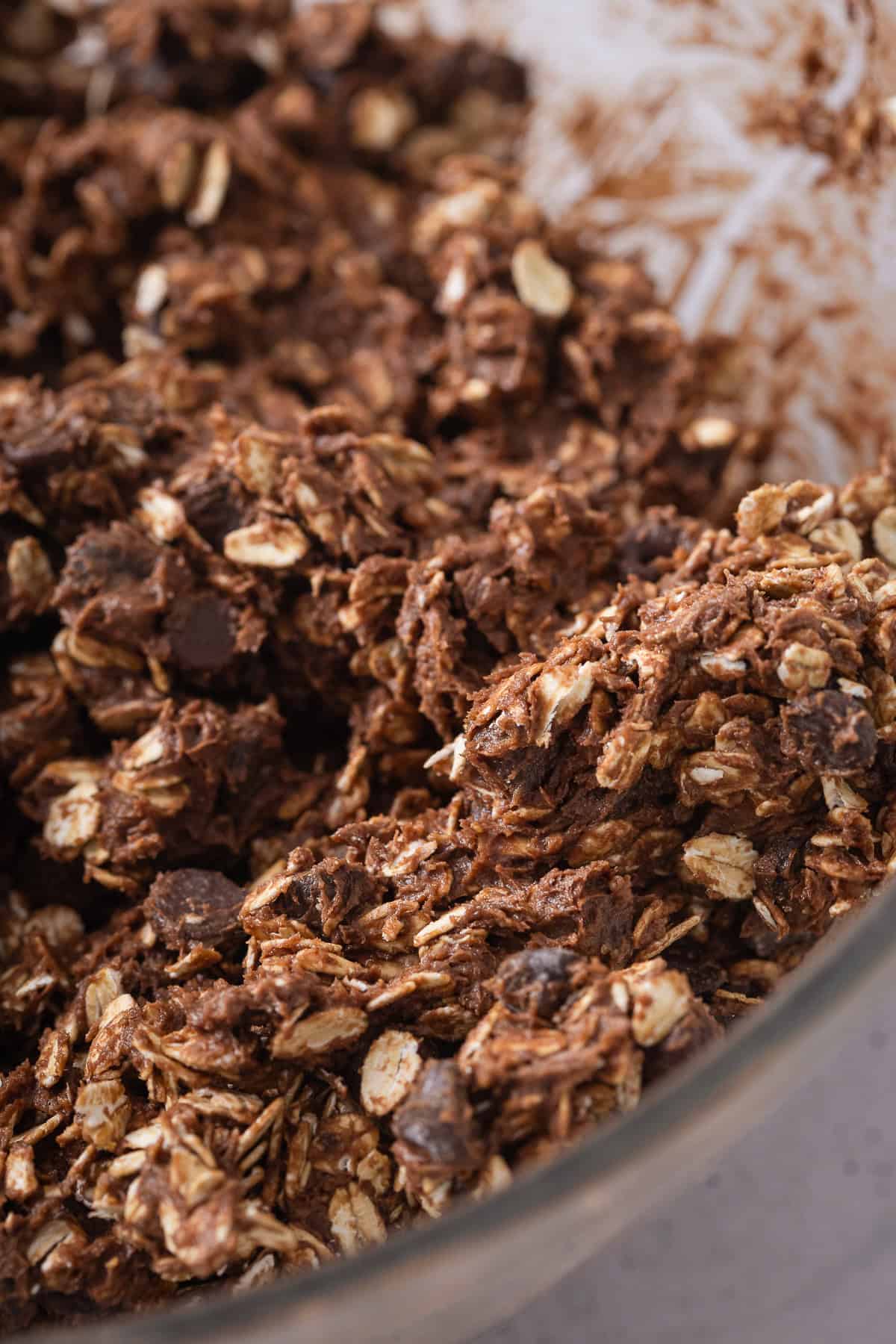 Close-up of chocolate oatmeal cookie dough with oats and chocolate chips.