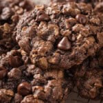 Close-up of chocolate oatmeal cookies with chocolate chips on a cooling rack.