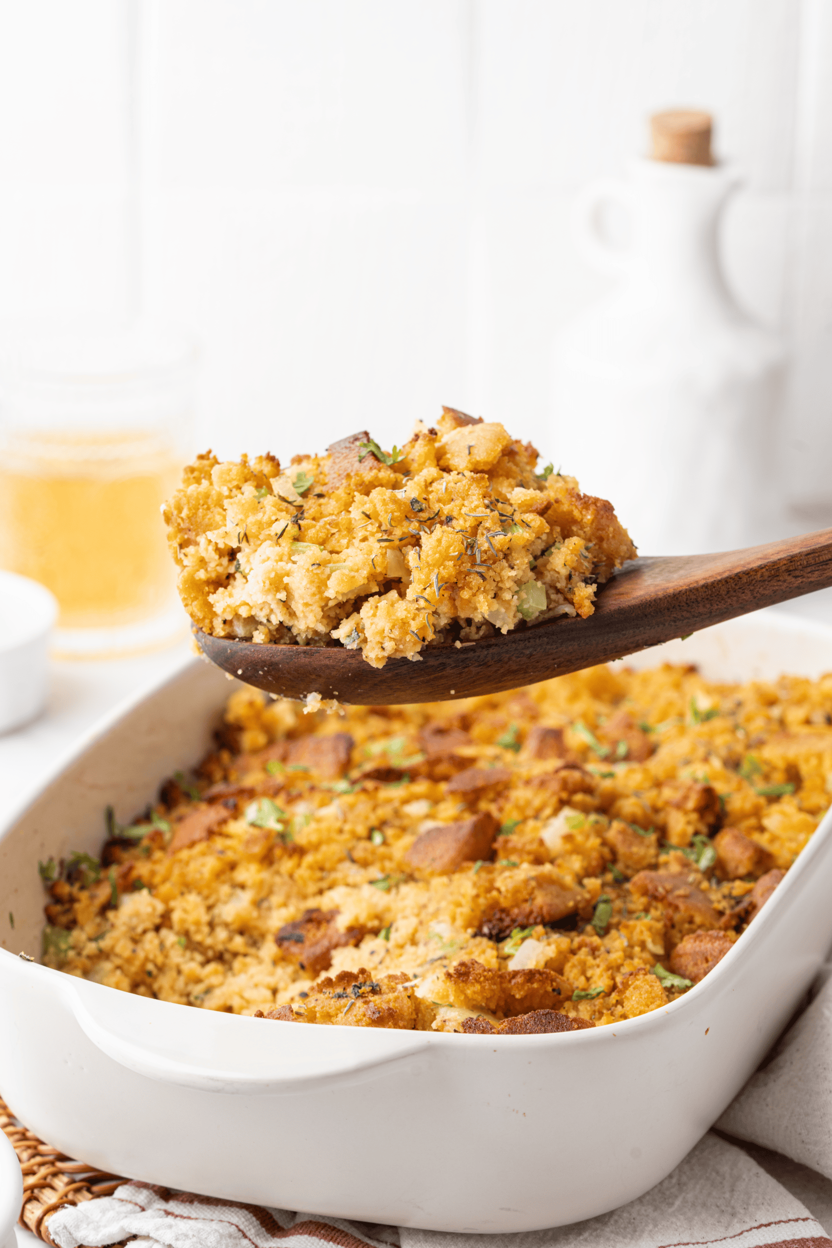 A generous spoonful of cornbread stuffing shows off the tender, crumbly center with crisp golden pieces, celery, onion, and herbs.