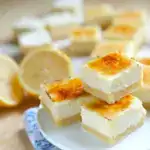 Lemon Creme Brulee Bars stacked on top of each other all on a white plate