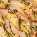 Flaky asparagus puff pastry bundles with pancetta and sesame seeds.