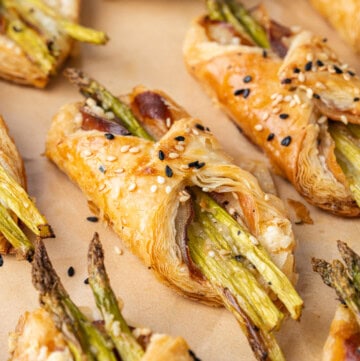 Flaky asparagus puff pastry bundles with pancetta and sesame seeds.