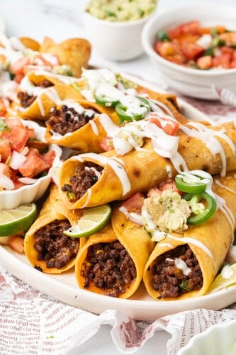 Crispy ground beef taquitos topped with guacamole, pico de gallo, jalapeños, and crema.