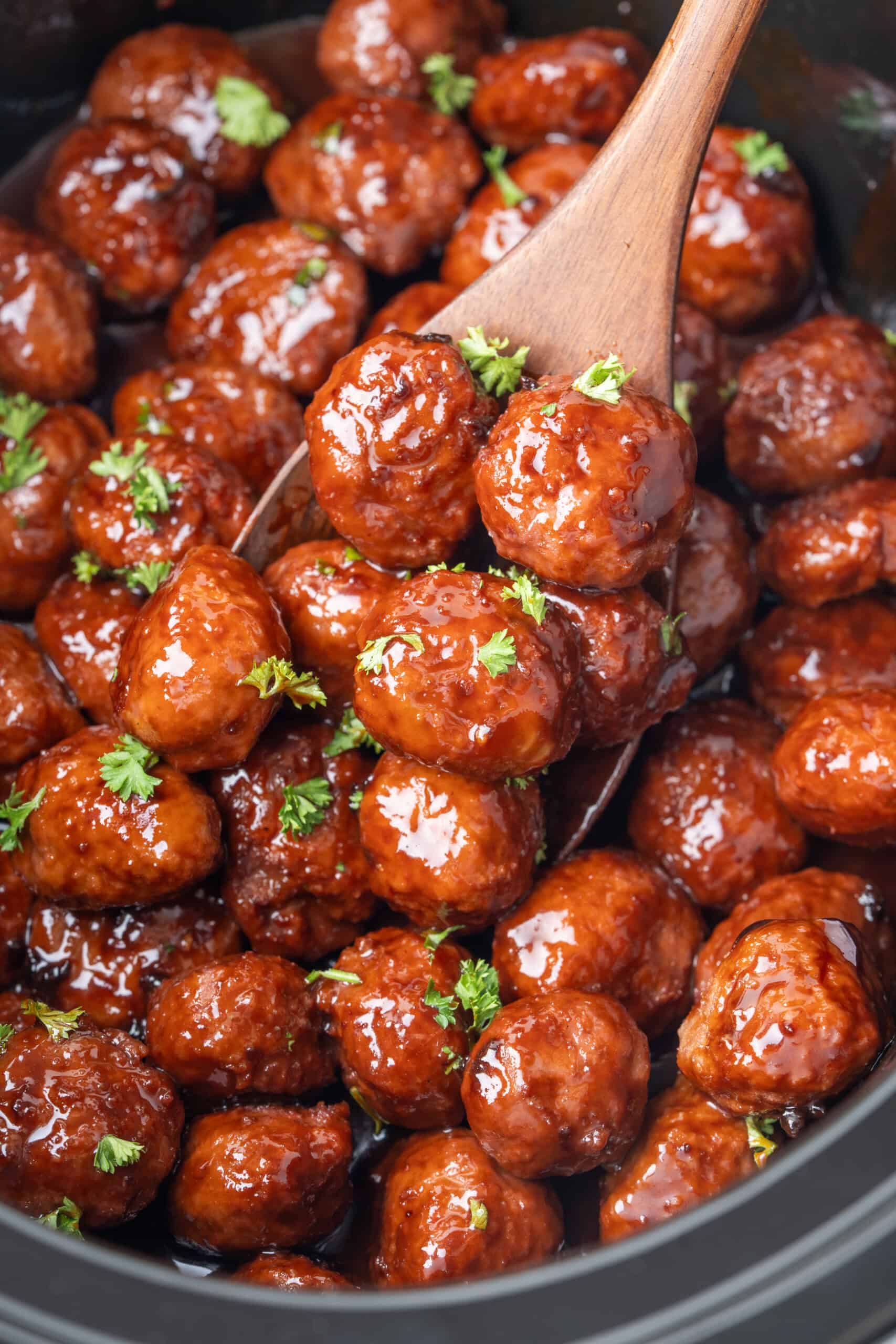 meatballs coated in glossy sauce and garnished with fresh parsley.