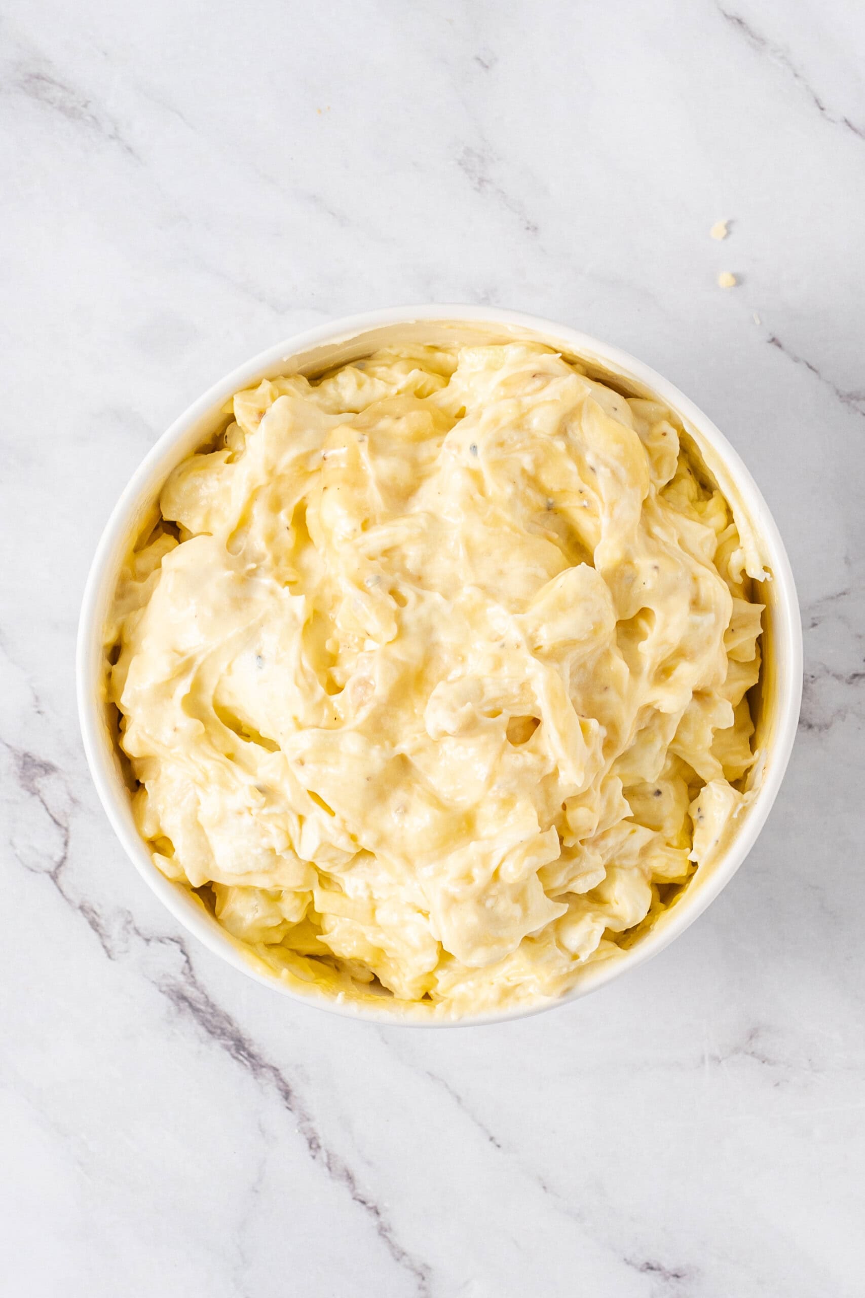 Creamy hashbrown mixture combined in a white bowl.