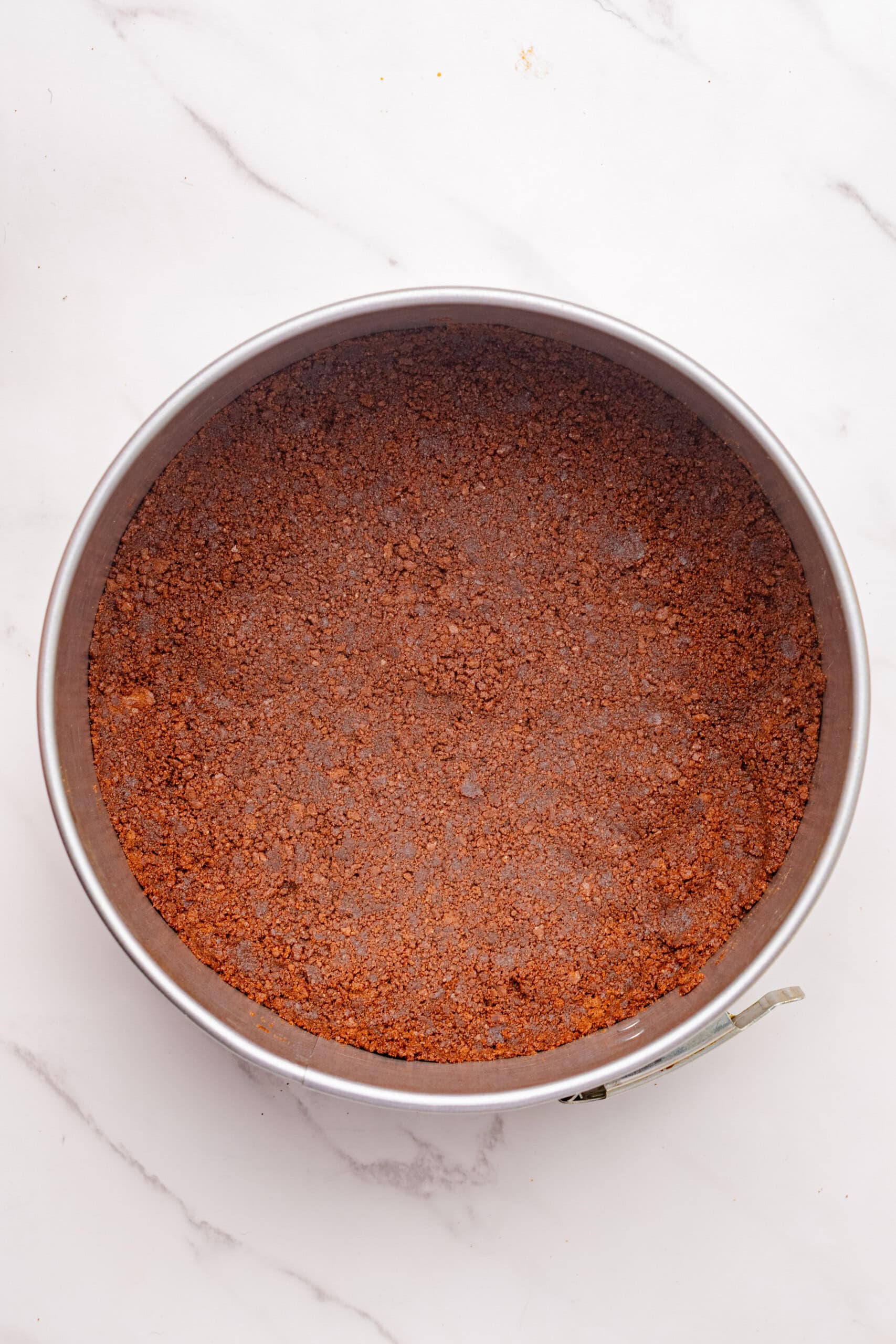Chocolate cookie crust pressed evenly into the bottom of a springform pan.