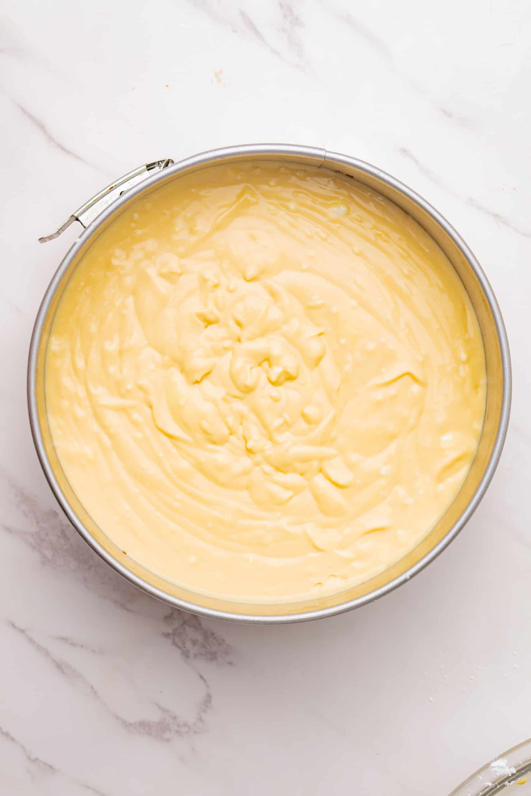 Irish cream cheesecake filling poured into a springform pan.