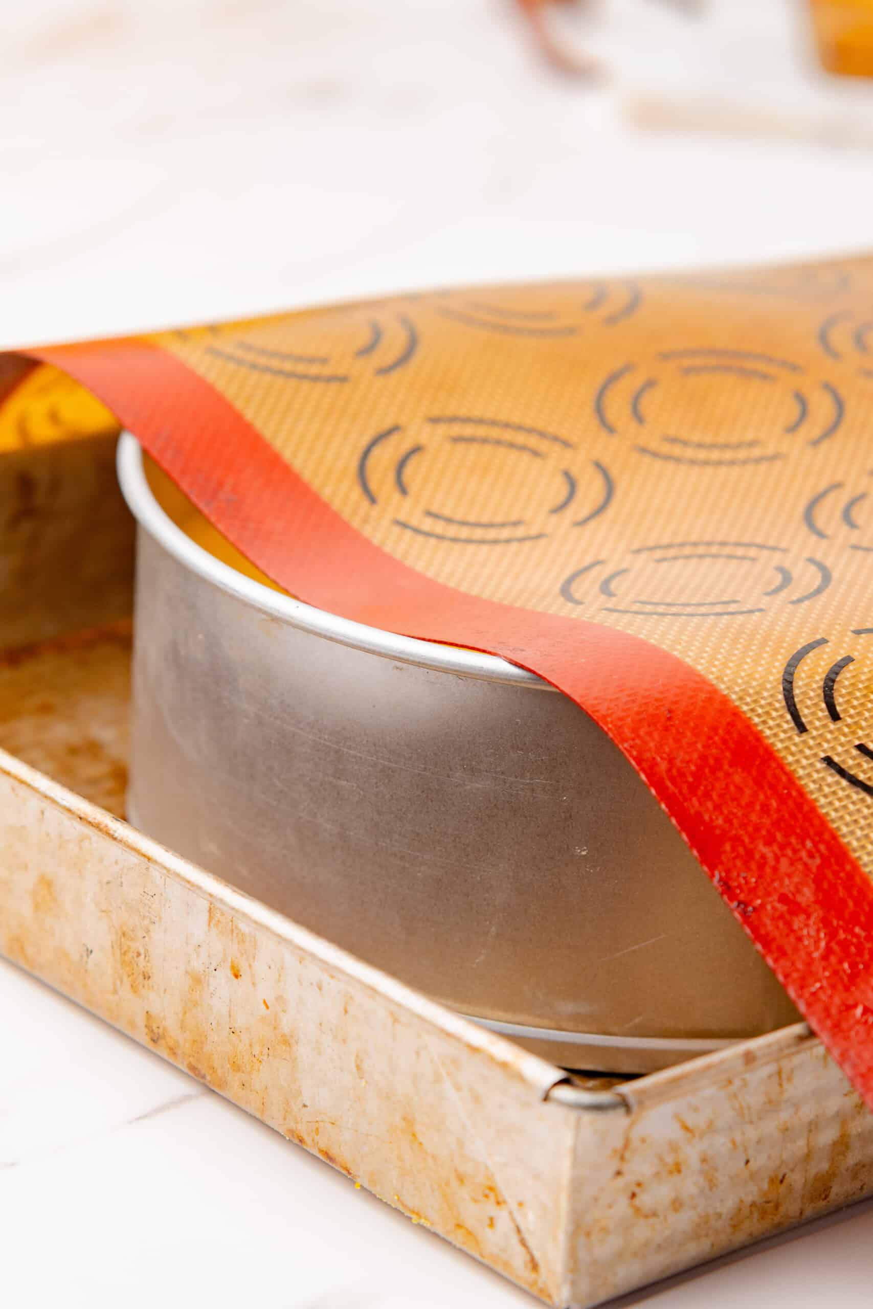 Springform pan covered with a silicone baking mat before baking.