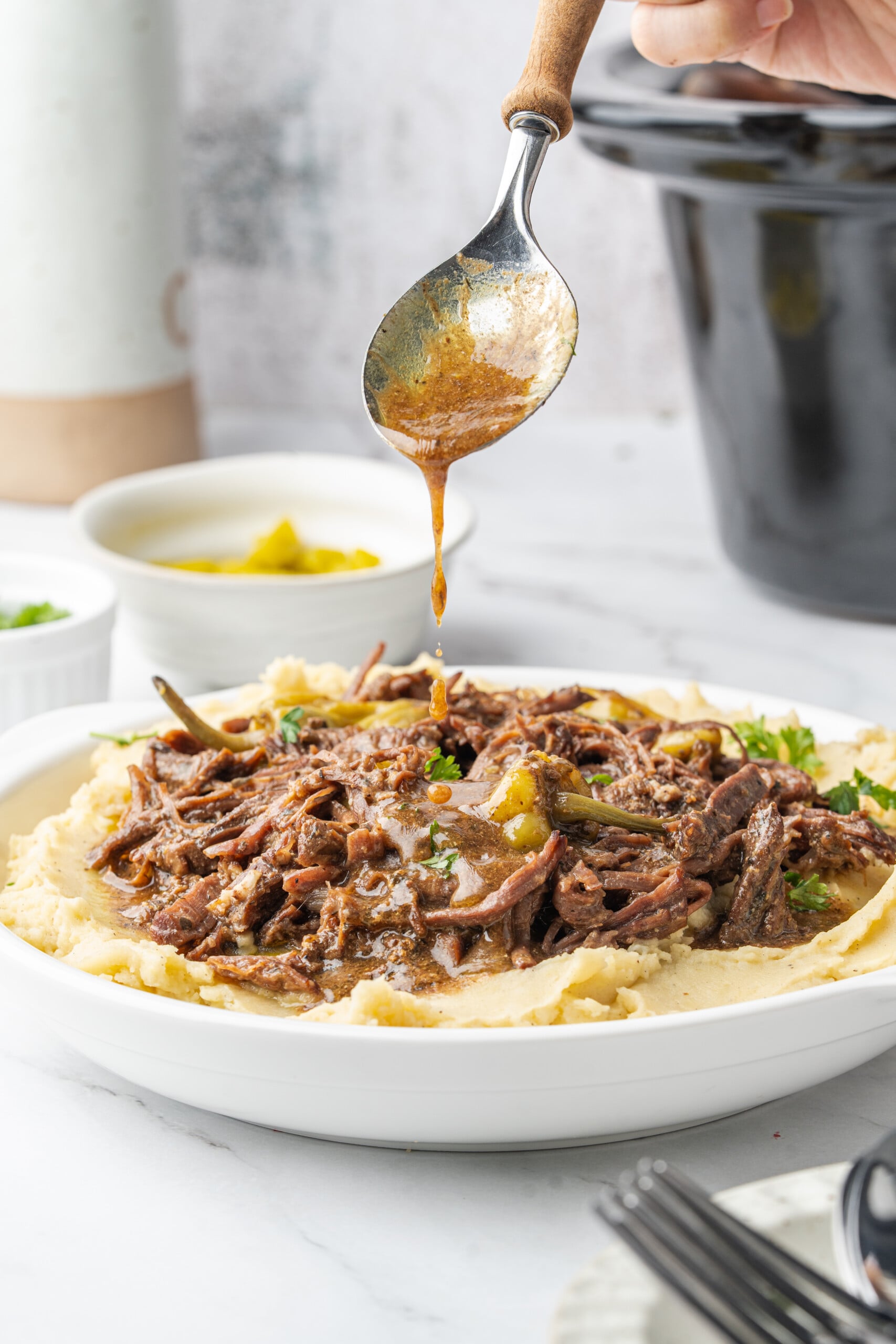 Mississippi pot roast with pepperoncini and gravy served over mashed potatoes.