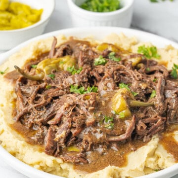 Mississippi pot roast with pepperoncini, gravy, and parsley served over mashed potatoes.