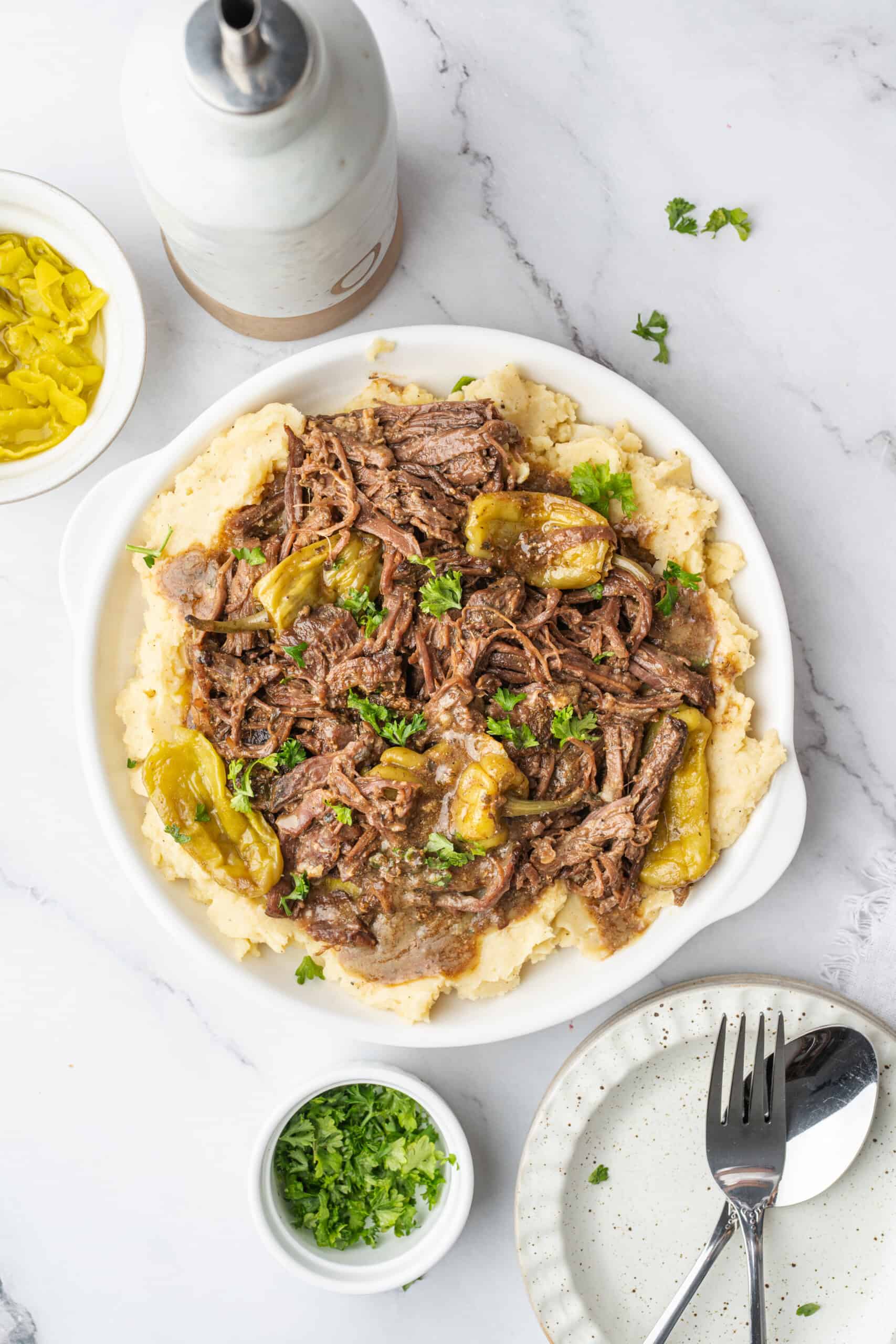 Mississippi pot roast with pepperoncini and gravy served over mashed potatoes.