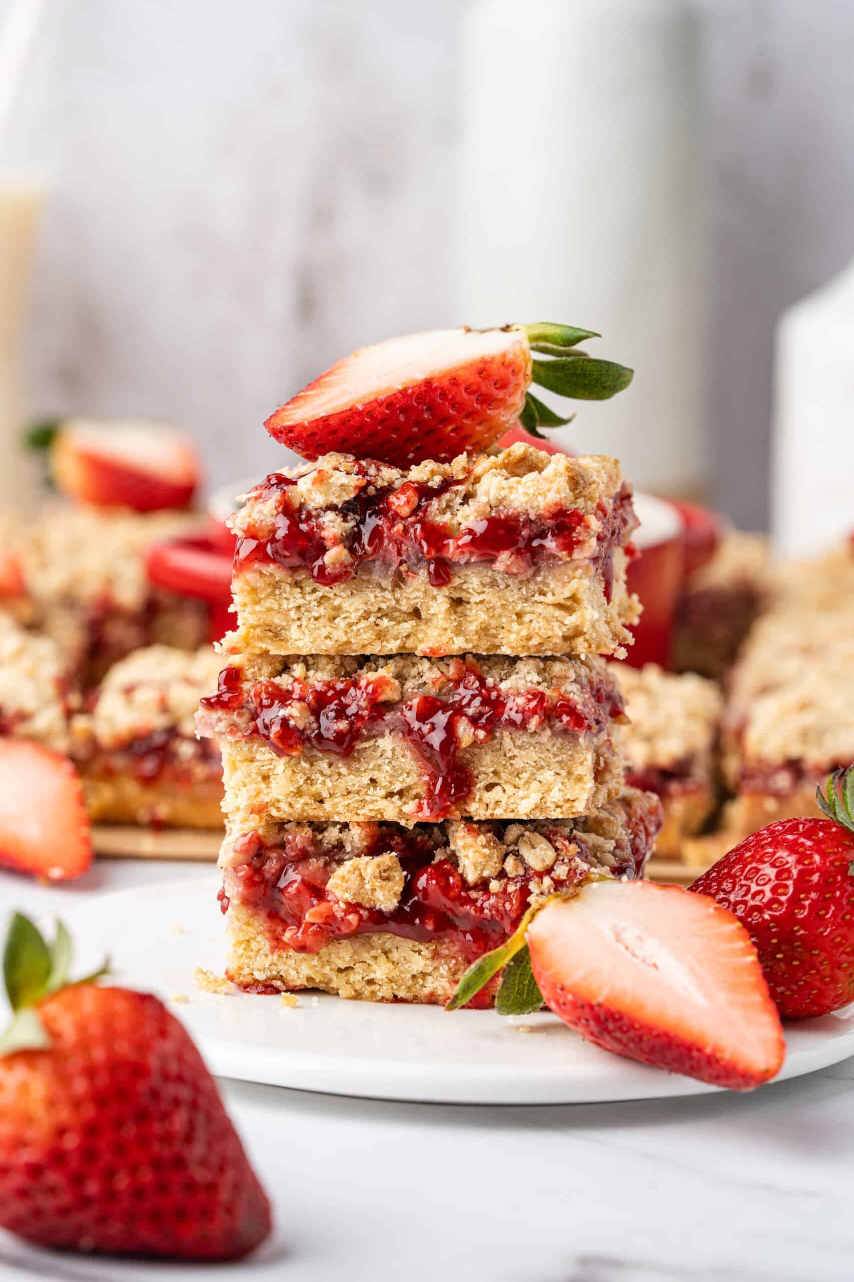 Stacked strawberry crumb bars with a golden crumble topping and fresh strawberries.