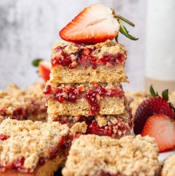 Stacked strawberry crumb bars with strawberry filling, oat crumble topping, and fresh strawberries.