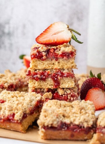 Stacked strawberry crumb bars with strawberry filling, oat crumble topping, and fresh strawberries.