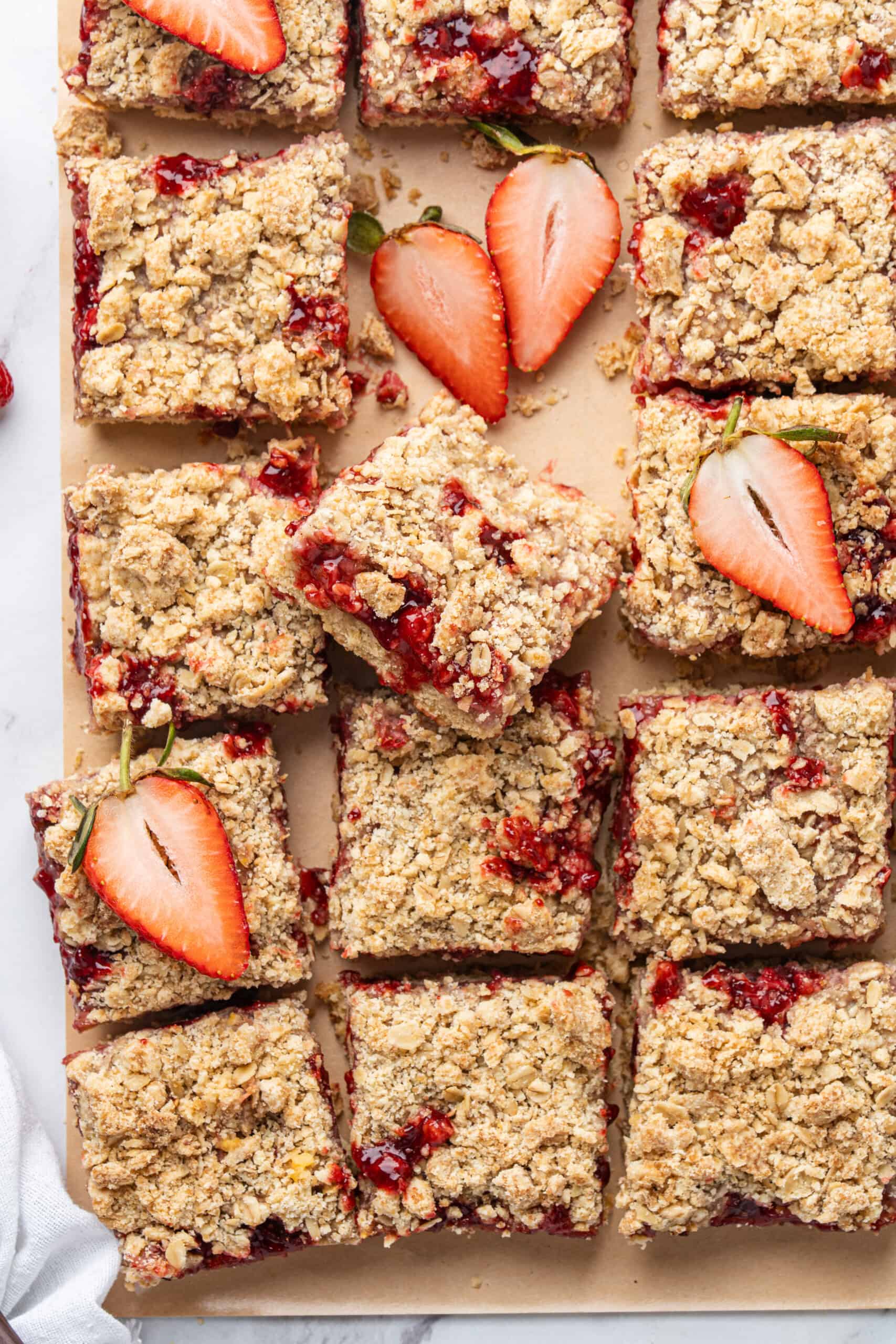 Strawberry crumb bars with a golden oat topping and fresh strawberry halves.