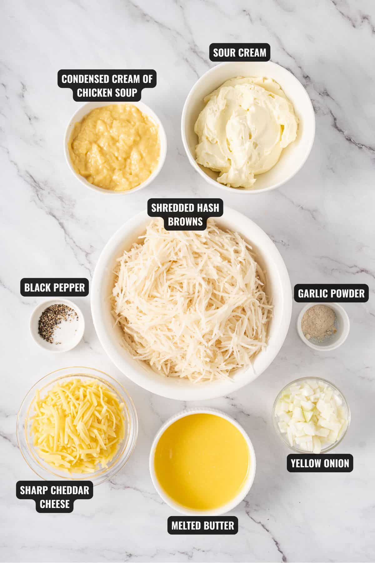 ingredients for cheesy hashbrown casserole recipe including shredded hash browns, condensed cream of chicken soup, sour cream, sharp cheddar cheese, melted butter, yellow onion, garlic powder and black pepper
