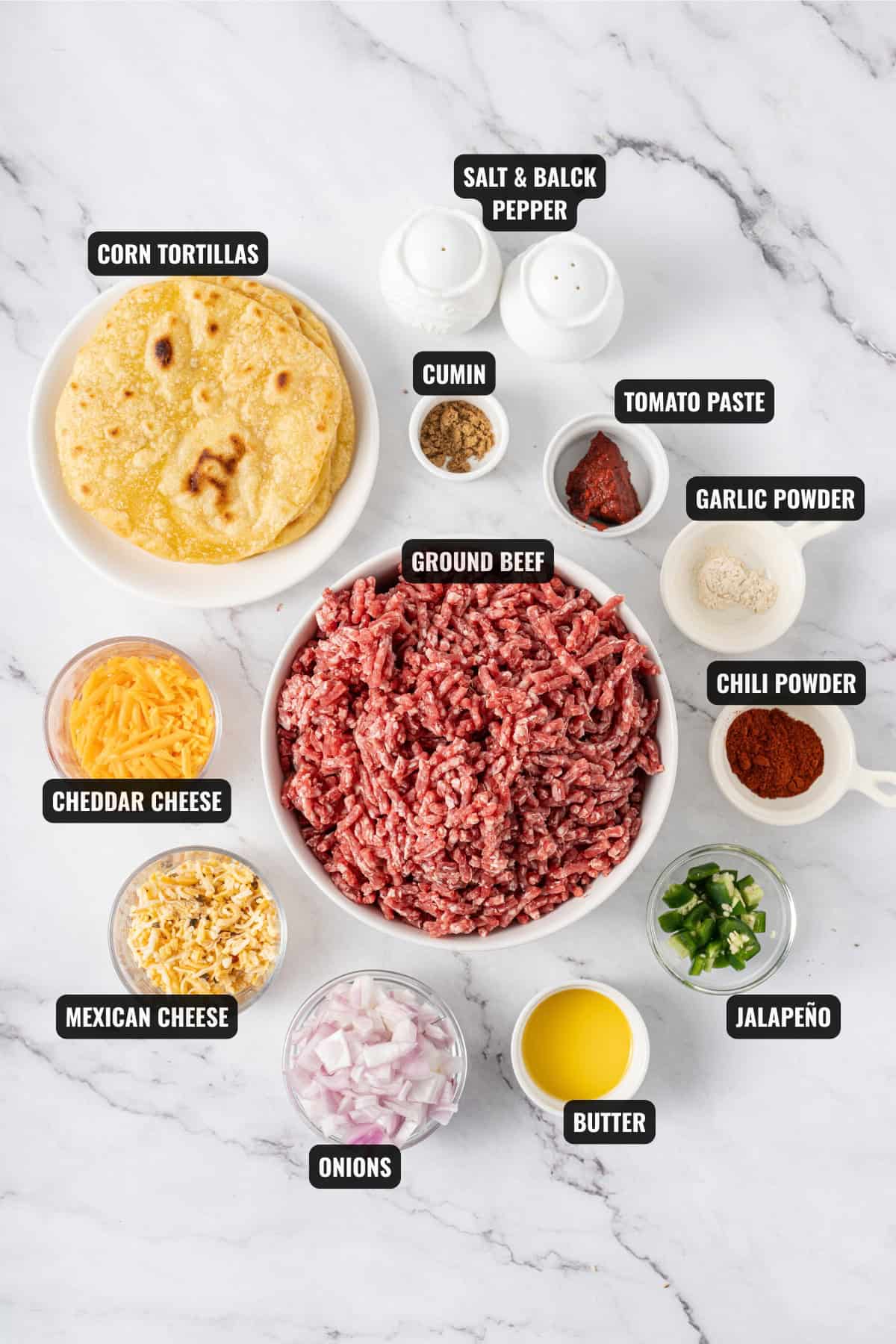 ingredients for ground beef taquitos recipe including grounf beef, corn tortillas, cumin, tomato paste, garlic powder, chili powder, Jalapeño, butter, onions, mexican cheese, and cheddar cheese.