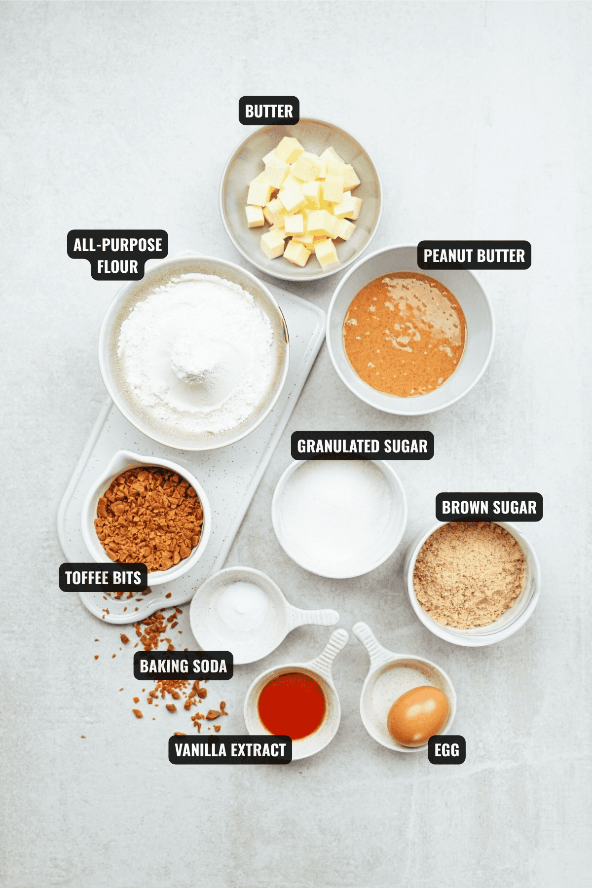 ingredients for peanut butter toffee cookies recipe including butter, all-purpose flour, peanut butter, granulated sugar. brown sugar, toffee bits, baking soda, vanilla extract and egg