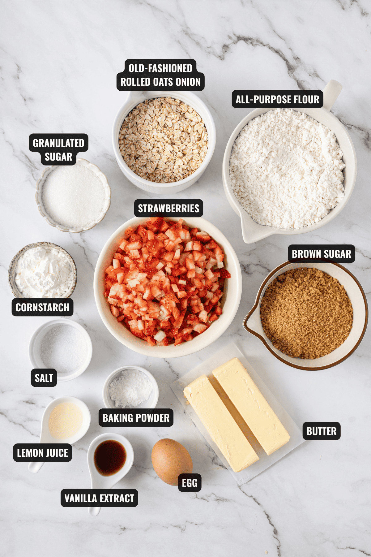 ingredients for strawberry crumb bars recipe including strawberries, oats, all-purpose flour, brown sugar, granulated sugar, cornstarch, salt, baking powder, lemon juice, vanilla extract, egg, and butter