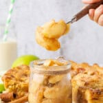 Homemade Apple Pie Filling with tender cinnamon-coated apples in a glass jar and a spoonful lifted above.