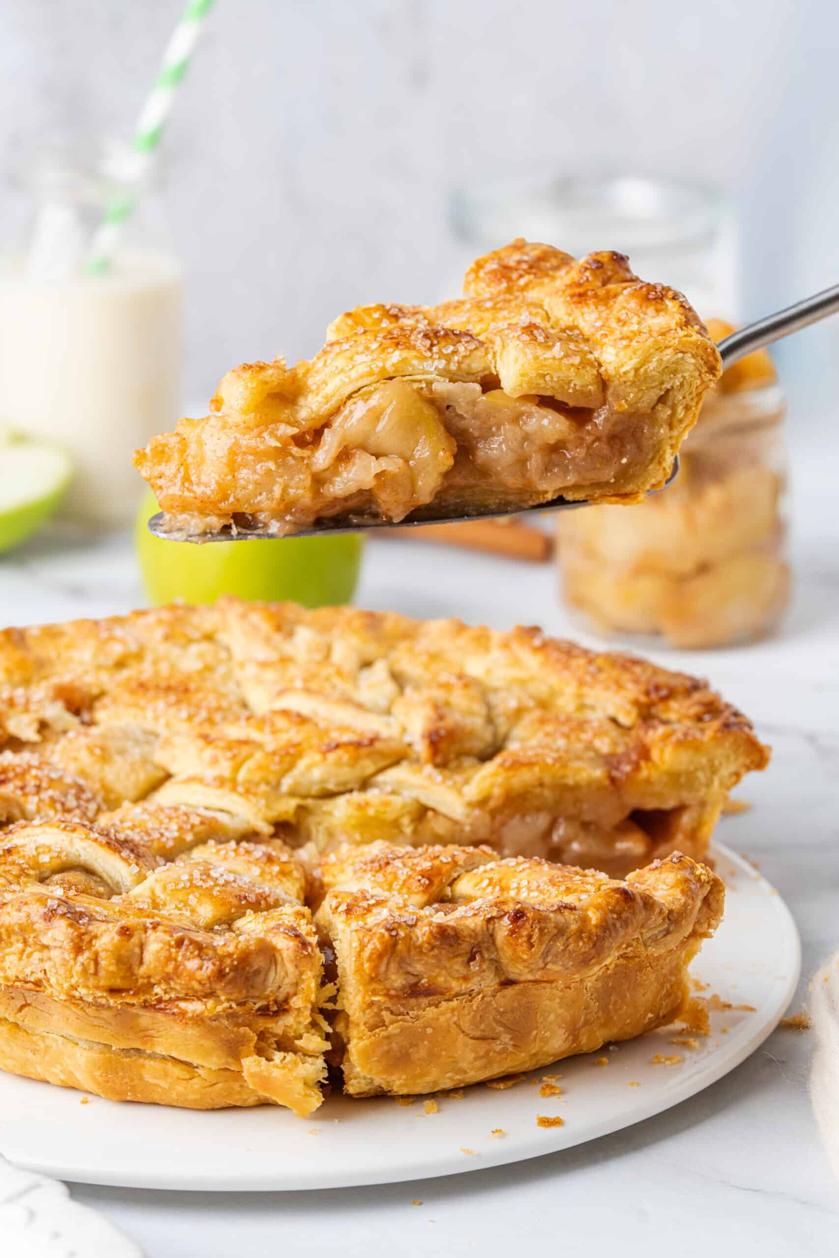 Homemade Apple Pie with a golden, flaky crust and cinnamon-spiced apple filling, served on a pie server.