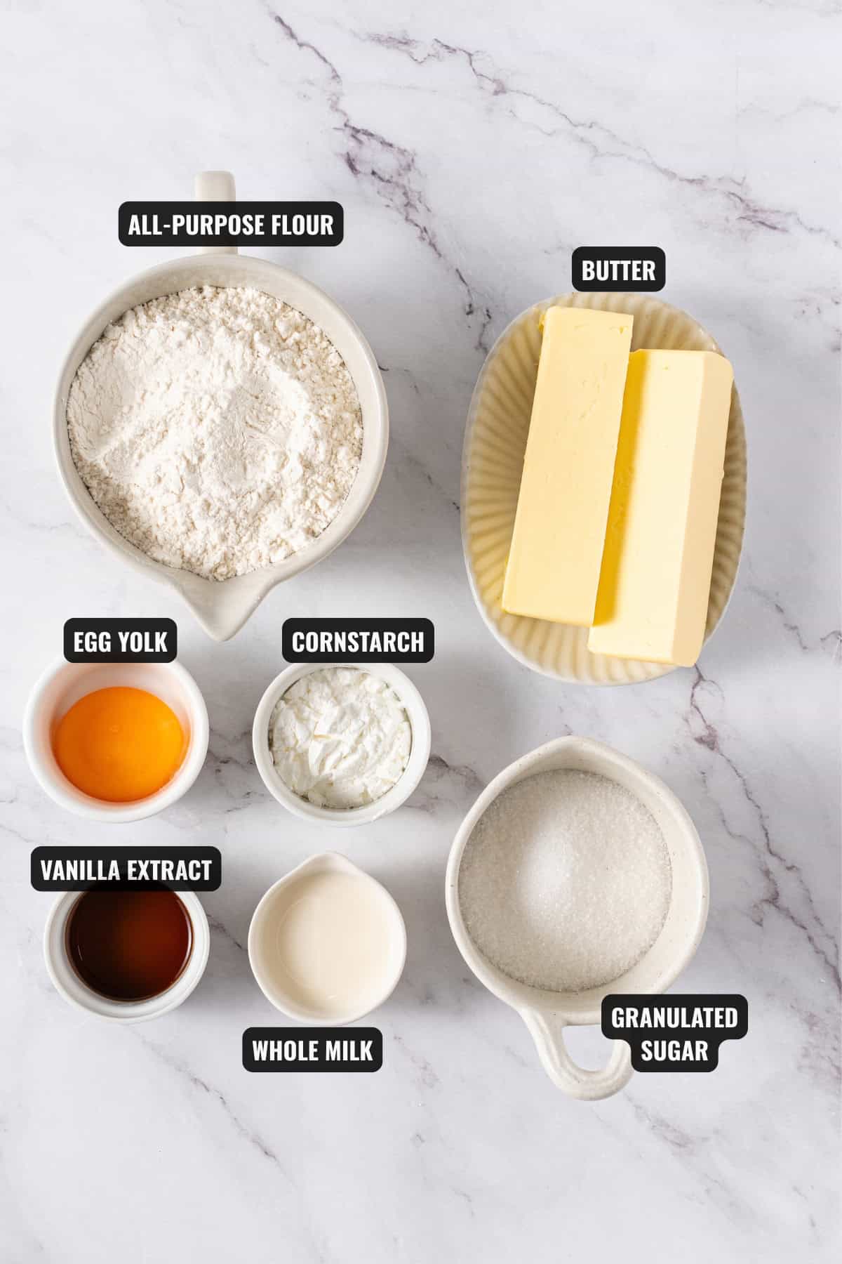 ingredients for butter cookies recipe including butter, all-purpose flour, egg yolk, cornstarch, vanilla extract, whole milk, and granulated sugar